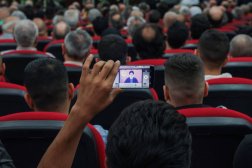 مناصر لـ«حزب الله» يلتقط صورة لنصر الله أثناء خطابه في الضاحية الجنوبية (رويترز)